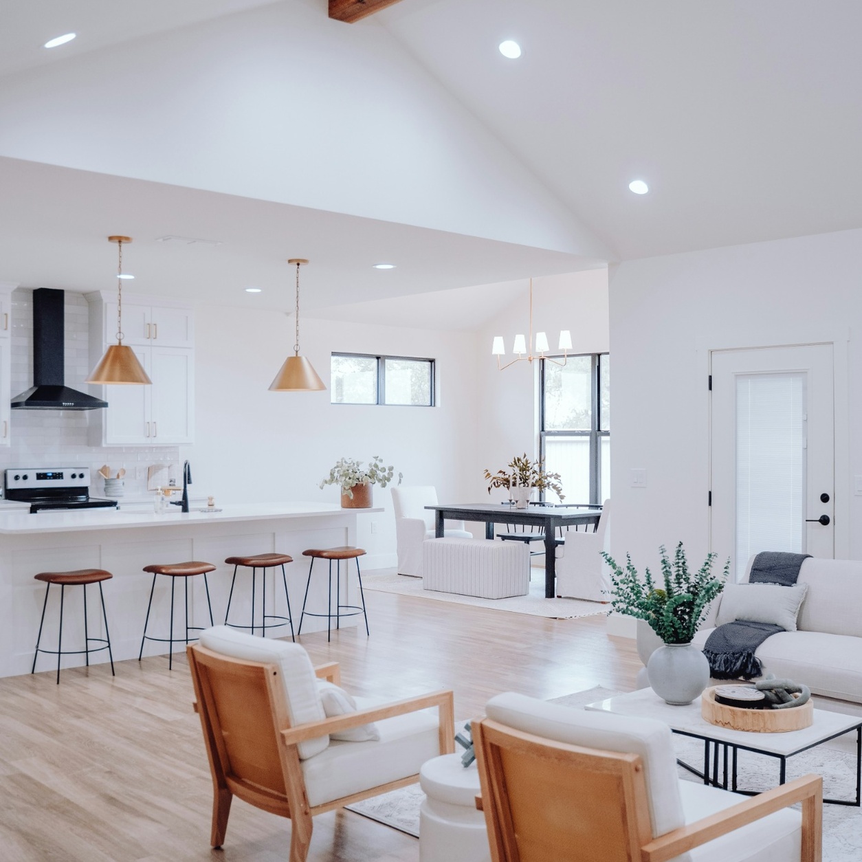 Modern open-concept home with light oak hardwood flooring professionally installed throughout the living room, dining room, and kitchen by Edmonton Flooring Ltd.